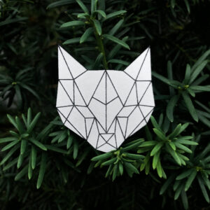 Gray reflector cat head with geometric pattern on a green background