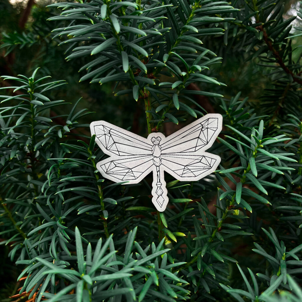 Hopeanvärinen heijastin-kiila, jossa on origami-kuvio, vihreällä taustalla